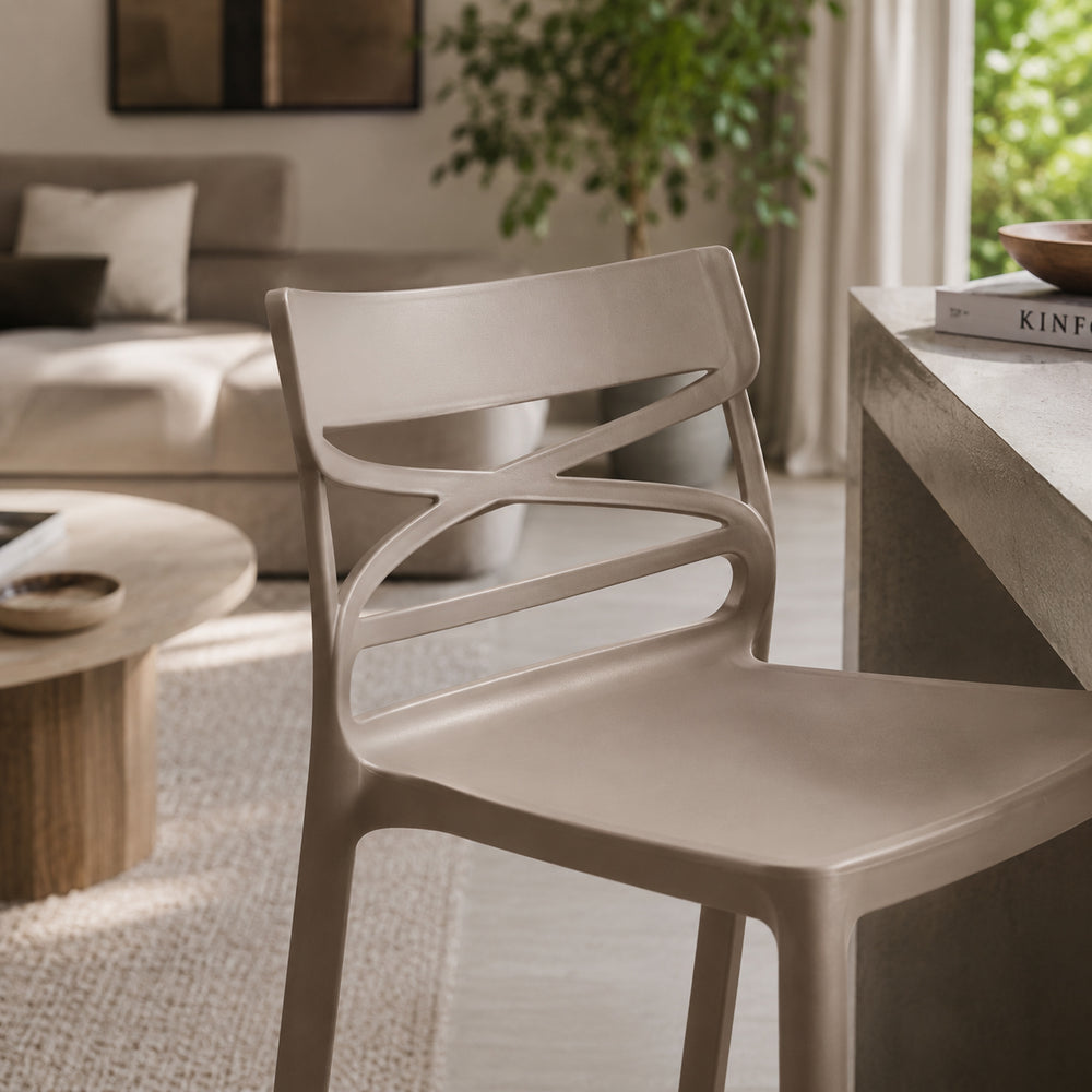 Sedia moderna in polipropilene color tortora con schienale dal design traforato e struttura monoscocca. Leggera, resistente e facile da pulire, ideale per cucina, sala da pranzo, soggiorno, bar e ambienti contract sia interni che esterni.