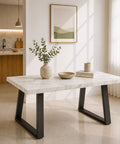 Tavolo da pranzo allungabile con piano in melaminico effetto marmo Carrara, struttura in metallo antracite e gambe trapezoidali, ideale per ambienti moderni e contemporanei