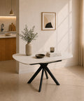 Tavolo allungabile Maui con piano in gres ceramico  effetto marmo Calacatta Gold lucido e basamento centrale a quattro gambe in metallo nero, design moderno ed elegante.